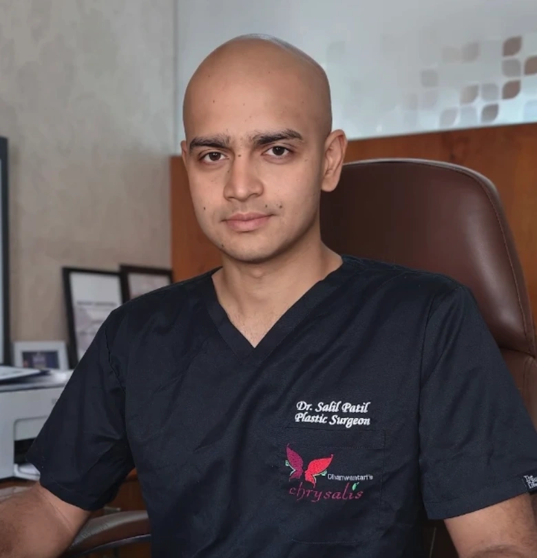 Dr. Salil Patil, plastic surgeon, in black scrubs with the Dhanwantari's Chrysalis logo